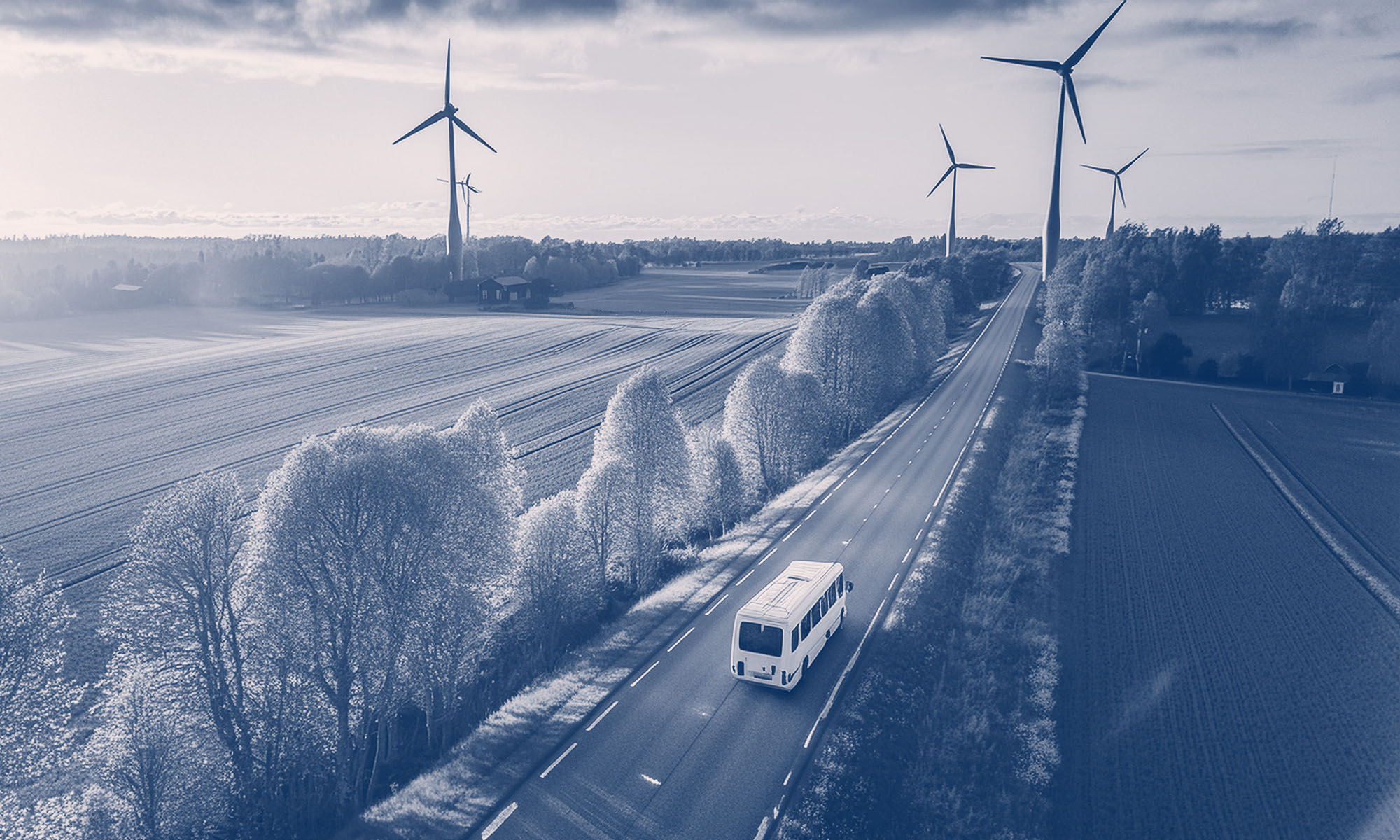 En AI-generarad bild som visar en minibuss snett uppifrån på en landsväg med tre vindkraftverk i fjärran