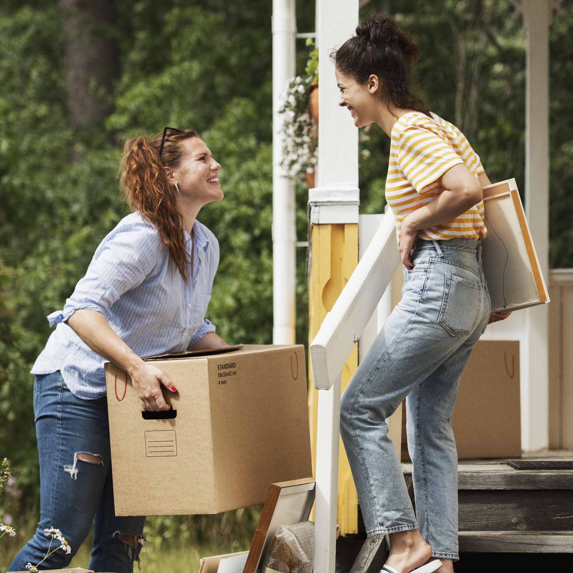 Två kvinnor hjälps åt att flytta in i nya huset