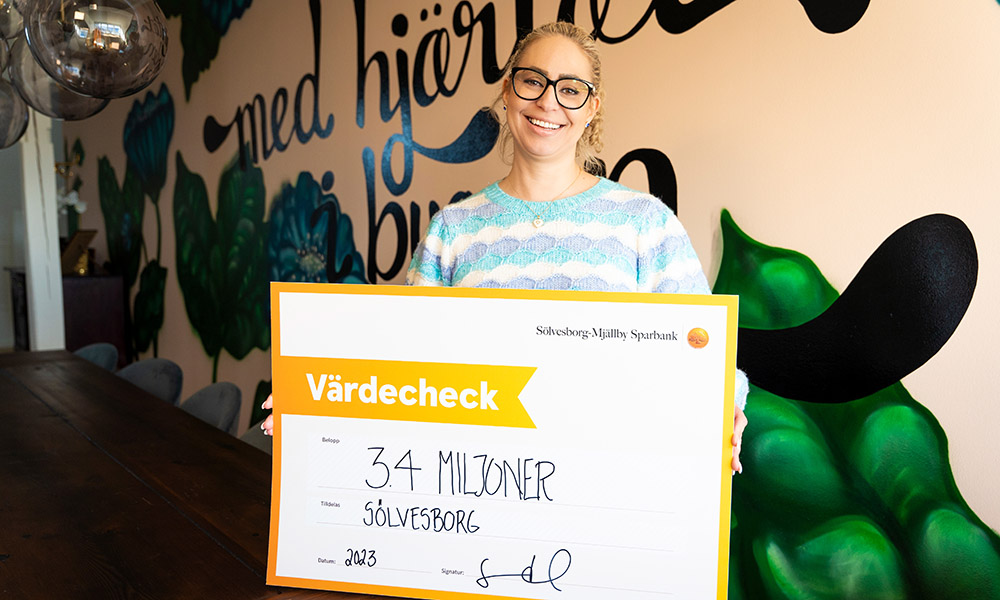 Susann Hammad, marknadschef, håller upp checken med 3,4 miljoner