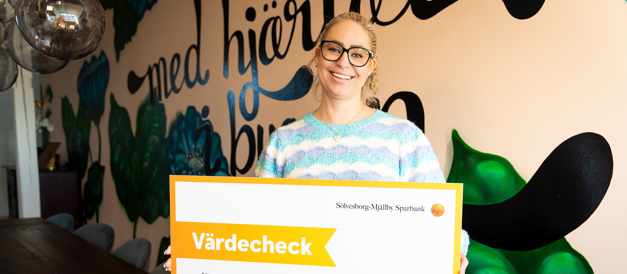 Susann Hammad, marknadschef, håller upp checken med 3,4 miljoner