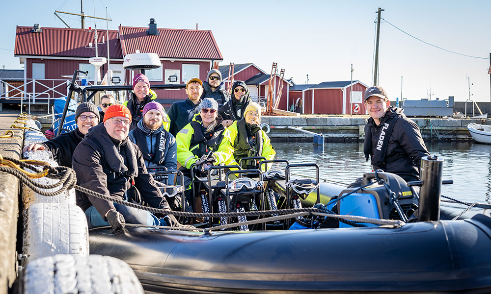 Gänget som jobbar med torskreven sitter tillsammans i en båt.