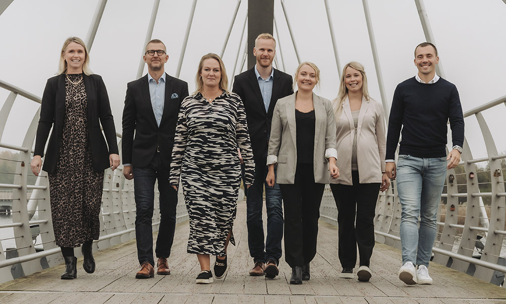 Företagsteamet går tillsammans mot kameran på Sölvesborgsbron