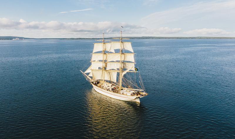 Drönarbild över Briggen Tre Kronor som seglar mot Sölvesborg i strålande solsken